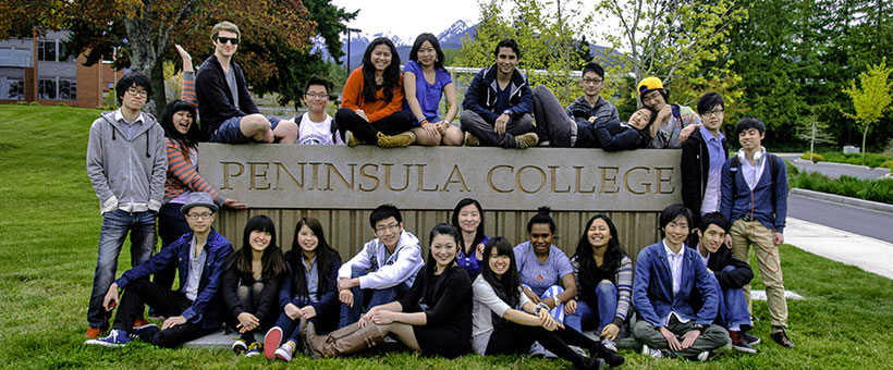 International students by the Peninsula College sign