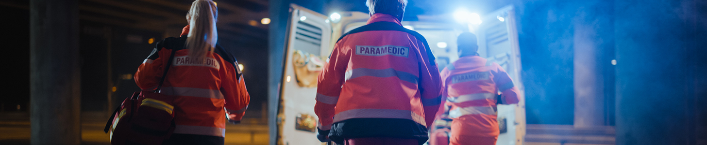 Paramedics moving a patient into an ambulance.