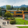 Students walking outside on campus with mountains and trees in the background