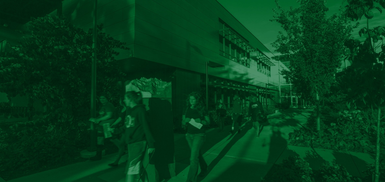 Students walking on campus behind buildings